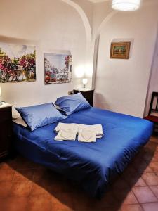 Una cama azul con dos toallas encima. en Florentine style apartment in San Frediano, en Florencia
