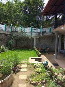 a backyard with a white picket fence and a garden at Jasmine Garden Inn in Ella