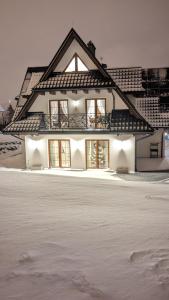 a white house with windows in the snow at Willa Giergonia in Bukowina Tatrzańska