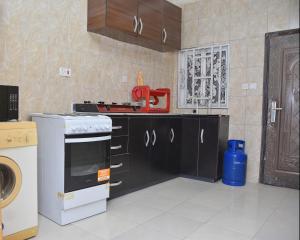 a kitchen with black cabinets and a red appliance at Orchids Service apartments in Lagos