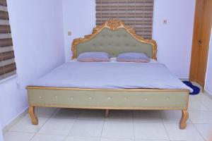 a bed with a wooden frame with two pillows on it at Orchids Service apartments in Lagos