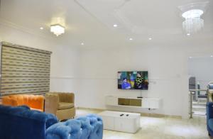 a living room with a blue couch and a tv at Orchids Service apartments in Lagos