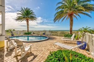 a patio with two palm trees and a swimming pool at Sunset Villas 3 in Clearwater Beach