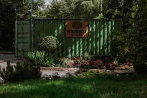 a green fence with a sign for a garden at Woodbox Istebna in Istebna +52 photos