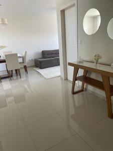 a white living room with a table and a couch at Temporada Cabo Frio in Cabo Frio