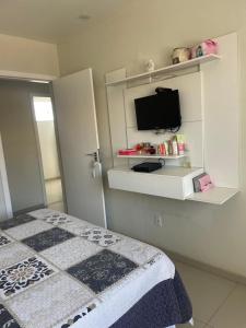 a bedroom with a bed and a tv on a wall at Temporada Cabo Frio in Cabo Frio