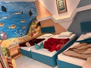 een kamer met 2 bedden en een schilderij van de oceaan bij Seaview Hotel Dahab in Dahab