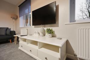 een witte dressoir met een flatscreen-tv aan de muur bij Richmond House - 5 Bed, Sleeps 10, Great for Workers & Groups, Netflix & FREE Parking in Manor