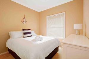 a bedroom with a white bed with a window at Booker Bay Ocean View in Booker Bay