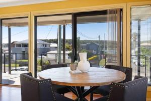 a dining room table with chairs and a vase on it at Booker Bay Ocean View in Booker Bay