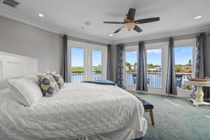 a bedroom with a bed with a ceiling fan and windows at Mainsail in Siesta Key +59 photos