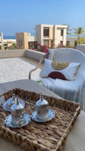 a wicker tray with serving dishes on a table at Sifah Beach Cottage in As Sīfah