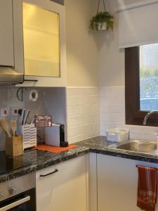 a kitchen with a sink and a counter top at Sifah Beach Cottage in As Sīfah