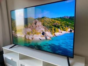 a flat screen tv sitting on top of a white dresser at Sifah Beach Cottage in As Sīfah