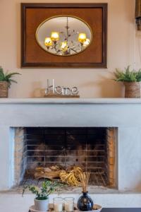 a fireplace with a mirror above it with a fire place at Villa KIMA Heated Pool in Episkopi (Heraklion)