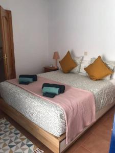 uma cama com duas almofadas num quarto em Casa Heli - Ruim appartement met dakterras in Polopos em Polopos