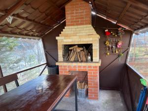 a fireplace in a tiny house with a table at Mini-Hotel Serpanok in Mykulychyn