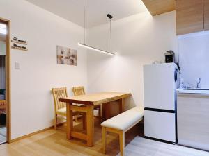 a kitchen with a wooden table and a refrigerator at Retreat Tachibana 旅趣・橘 in Osaka