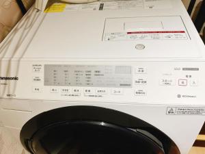 a white washing machine with a box on top of it at Retreat Tachibana 旅趣・橘 in Osaka