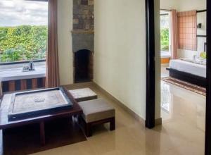 Corbett Wild Nature View Resort في رامناجار: حمام مع حوض استحمام ومقعد ومدفأة
