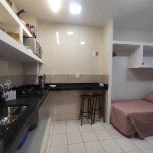 a kitchen with a counter and a bed in a room at Kitnet no centro de Guarapari in Guarapari