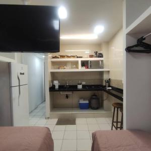 a small kitchen with a sink and a refrigerator at Kitnet no centro de Guarapari in Guarapari