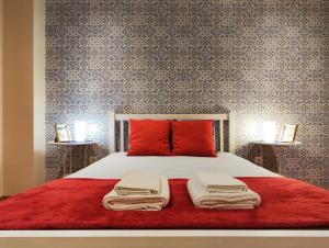 a bedroom with a bed with red pillows and wallpaper at Portus Cale Apartment in Águas Santas