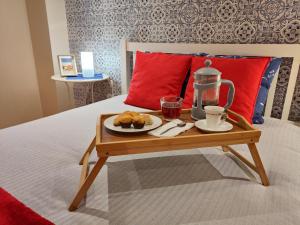 a tray of food on a bed with a coffee table at Portus Cale Apartment in Águas Santas