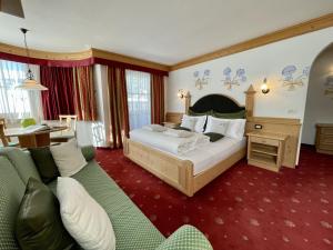 ラ・ヴィッラにあるB&B Tamarindoのベッドとソファ付きのホテルルーム