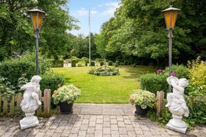 un jardín con estatuas y flores en un parque en Lynge kro & Hotel 