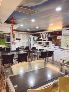 a restaurant with tables and chairs and a kitchen at Bin Chen Business Hotel in Hsinchu City