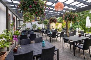 a restaurant with tables and chairs and plants at Lynge kro & Hotel in Lynge