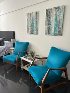2 sillas azules y una mesa de centro en una habitación en Apartments Belgrano en Buenos Aires