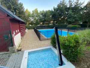 uma piscina em frente a uma casa vermelha com em Le Petit Nid du Port Crouesty - Studio au calme em Arzon