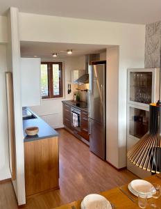 a kitchen with a stainless steel refrigerator and wooden floors at Holiday Home Ylläs Villas in Ylläsjärvi