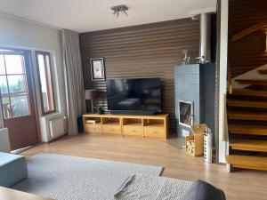 a living room with a television and a fireplace at Holiday Home Ylläs Villas in Ylläsjärvi