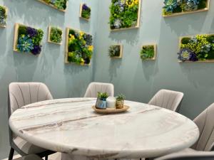 a white table with chairs and flowers on a wall at Sunway Ipoh - DamaiStay - 5min to Tambun - 20Pax in Tambun