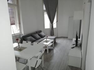 een woonkamer met een bank en een tafel bij Museum Park Szell str - Downtown 4 Bedroom+Living Room apartment in Szombathely