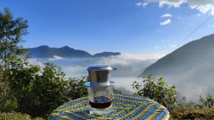 una mesa con una taza de café en la cima de una montaña en Tavan View Homestay, en Sa Pa