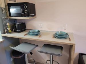 een keuken met een aanrecht met borden en een magnetron bij Beau studio dans le Vieux-Lille in Lille