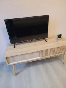 een flatscreen-tv op een houten tafel bij Beau studio dans le Vieux-Lille in Lille