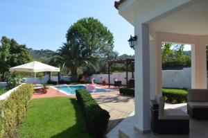 a backyard with a swimming pool and a house at Villa Platanias in Agia Paraskevi