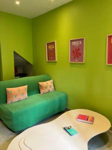 a green living room with a green couch and a table at Appartement Ibiz’Arles in Arles