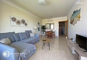 uma sala de estar com um sofá azul e uma mesa em Marshi Apartamento Burgau em Burgau