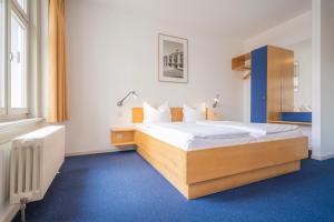 ein Schlafzimmer mit einem großen Bett und einem blauen Teppich in der Unterkunft Hotel Alt-Weimar in Weimar