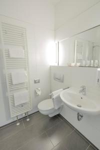 a white bathroom with a toilet and a sink at Alt-Weimar in Weimar