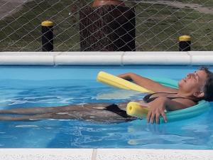 una mujer en una piscina con un frisbee en Complejo Quimpe en Villa Giardino