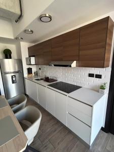 a kitchen with white cabinets and a stainless steel refrigerator at EÓN 13 - Apto moderno con aire acondicionado in Guatemala