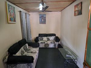 ein kleines Wohnzimmer mit Sofas und einem Deckenventilator in der Unterkunft Brufut Residence in Brufut