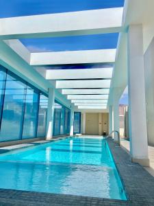 a swimming pool in a building with windows at Apartamento Alma Capital in Iquique